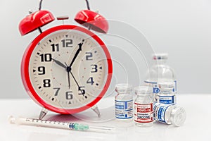 Covid Vaccine dose bottle with Time clock for Coronavirus Vaccination timing concept