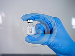 Covid-19 vaccine vial held by the gloved hand
