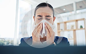 Covid, virus and sick with a business woman blowing her nose with a tissue and sneezing while working in her office