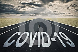 Covid-19 written on a road, dark clouds, coronavirus epidemic concept photo