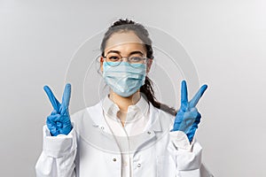 Covid19, coronavirus, healthcare and doctors concept. Portrait of optimistic asian female doctor ask to stay safe, wear
