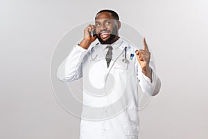 Covid19, pandemic and online medicine concept. Professional handsome african-american doctor consult patient on phone