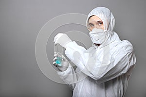 Covid19 vaccine in doctors hands. Doctor in protective medical suit, biological hazard, medical mask gloves on gray background.