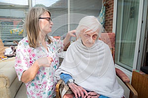 Elderly woman has hair cut by her carer during Corona virus lockdown at home