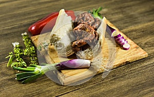 Cow bowels presented on a wooden board with ingredients,