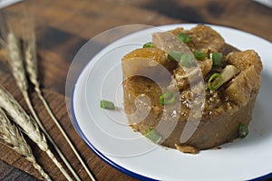 Cow skin meat cooked with spicy peanut sauce with onion leaves as garnish.