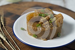 Cow skin meat cooked with spicy peanut sauce with onion leaves as garnish.