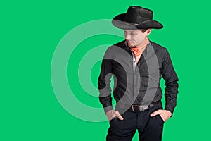 Cowboy in a black shirt looks to the side and to the bottom