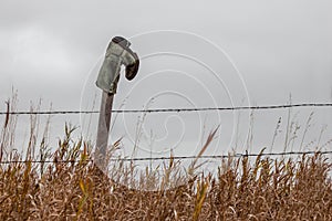 Cowboy boot hanging on a fence post