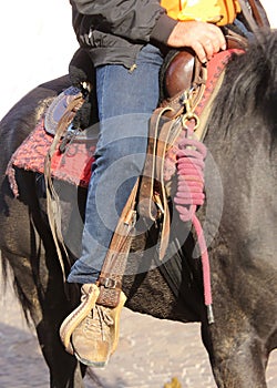 Cowboy boot in the stirrup of the horse during the ride