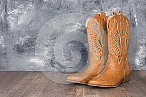 Cowboy boots against a gray wall. Adventure and travel concept