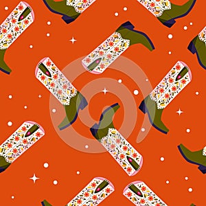 Cowboy boots with flowers and hearts on vibrant orange background, seamless pattern. Cute festive repeat pattern. Bright colorful