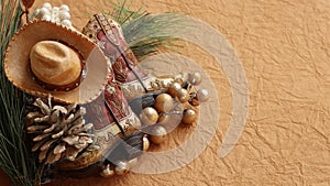 Cowboy boots and hat with christmas decorations on a brown background