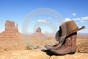 Cowboy boots and hat in front of Monument Valley