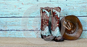 Cowboy boots and hat on a teal background