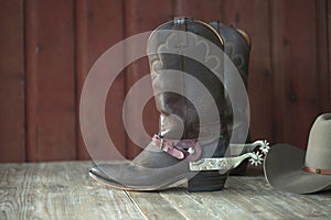 Cowboy boots, spurs and hat on old wood background