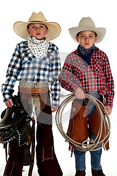 Cowboy brothers wearing hats holding saddle and rope