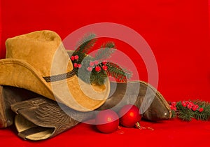 Cowboy Christmas.American West traditional boots and hat on christmas red background