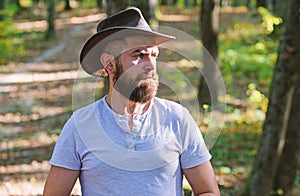 Cowboy couture. Bearded man in cowboy hat walk in park outdoor. man hipster in autumn forest. Spring sunny weather