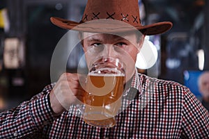 Cowboy drinking beer at the saloon