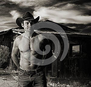 Cowboy at dusk in front of an old cabin