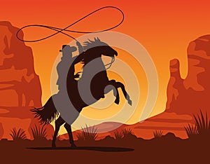 cowboy figure silhouette in horse lassoing sunset lansdscape scene