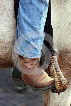 Cowboy foot in the stirrup of the horse