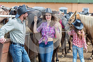 cowboy girl with her perents feed the horses