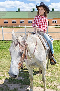 cowboy girl on horseback looks into the photo