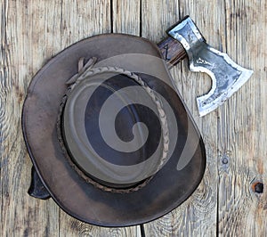 cowboy hat and ax on old wooden