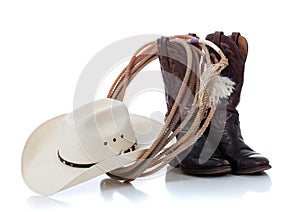 Cowboy hat, boots and lariat on white photo