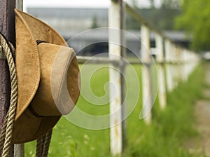 Cowboy hat and lasso on fence American ranch