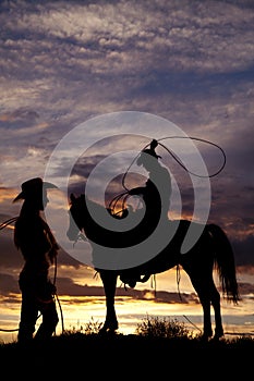 Cowboy on horse swinging rope