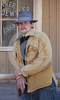 Cowboy leaning on rail.