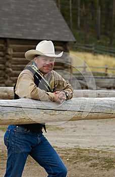 Cowboy Leans on Fence photo