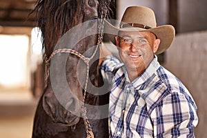 Cowboy, man and horse in stable with smile in portrait for care, growth or development at farm, ranch or countryside