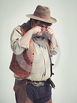 Cowboy person, crying and sad in studio, bandit and plus size man on white background. Dress up, fake and Halloween