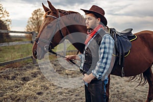 Cowboy poses with horse on texas farm