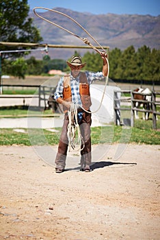 Cowboy, ranch and lasso in boots, sun and straps for wrangler and Texas farmer at stable. Mature man, wild west and