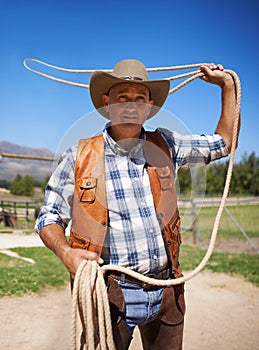 Cowboy, ranch and lasso in outdoor, sun and straps for wrangler and Texas farmer at stable. Mature man, wild west and