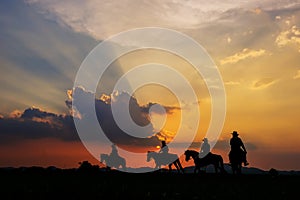Cowboy silhouette on horseback with mountain view and sunset sky