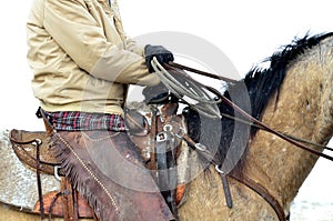 Cowboy sits his horse during a light snowfall