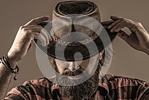 Cowboy style. Handsome young man adjusting his cowboy hat. Cowboys in hat. Handsome bearded macho. Man unshaven cowboys