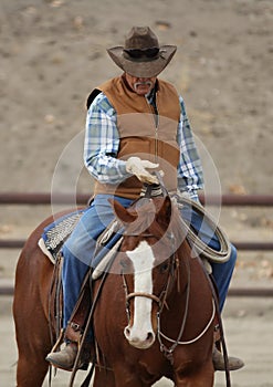 A cowboy is training a horse.