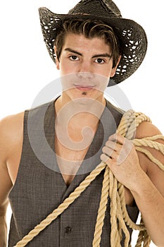 Cowboy in vest with rope on shoulder close