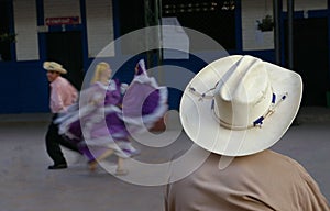 Cowboy watching hispanic dancers