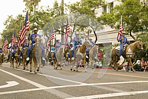 Cowboys on horseback with American Flags displayed during opening day parade down State Street, Santa Barbara, CA, Old Spanish Day