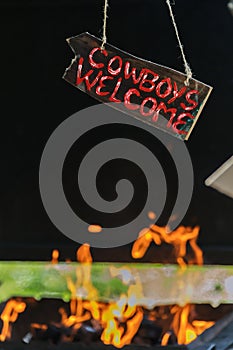 Cowboys welcome, cowboys are invited to barbecue, fire and welcome sign