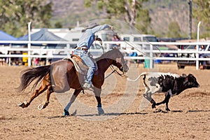 Cowgirl Competing In A Calf Roping Event At A Country Rodeo