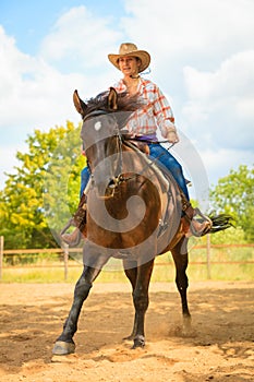 Cowgirl doing horse riding on countryside meadow